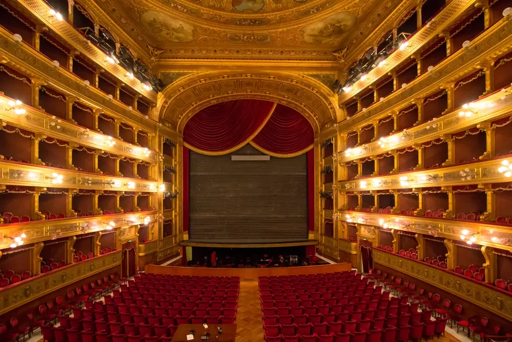Wide angle shot of the Teatro Massimo in Palermo, Italy. An elaborate gold and red theater.