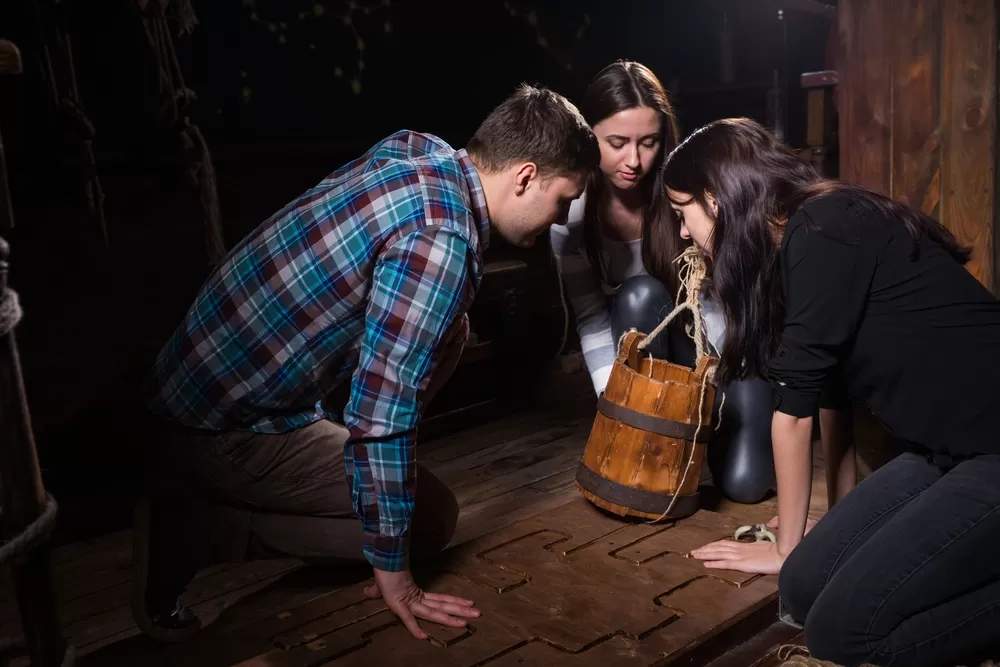 Three people on the ground working to solve a puzzle together.