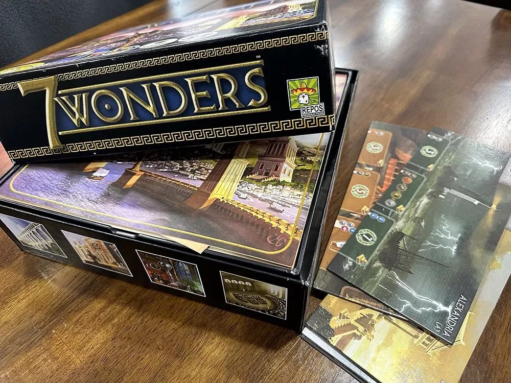 The 7 Wonders board game opened to reveal its contents.