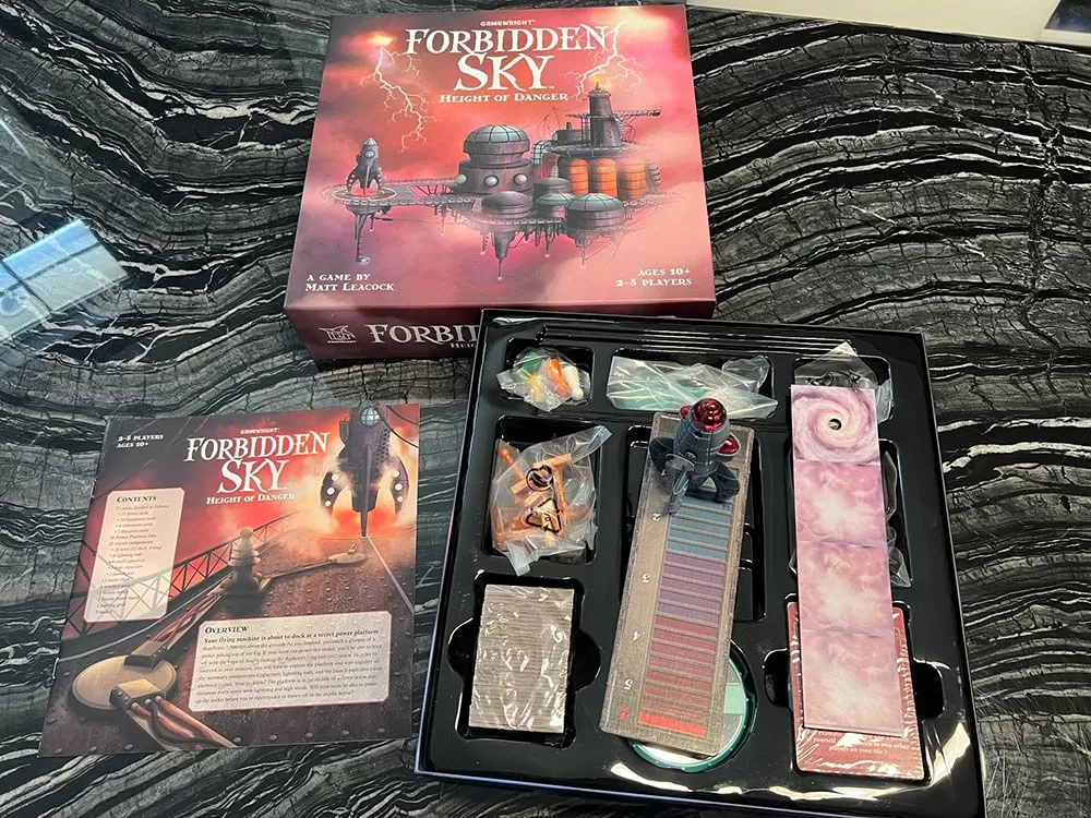 The Forbidden Island Board game box opened to show its rulebook and components.