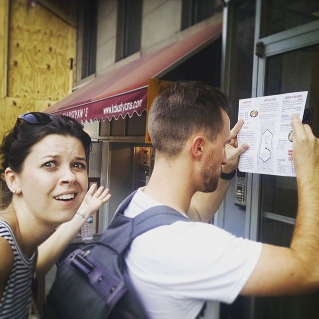 Woman shrugging with a puzzled expression at a man working on a scavenger hunt clue.