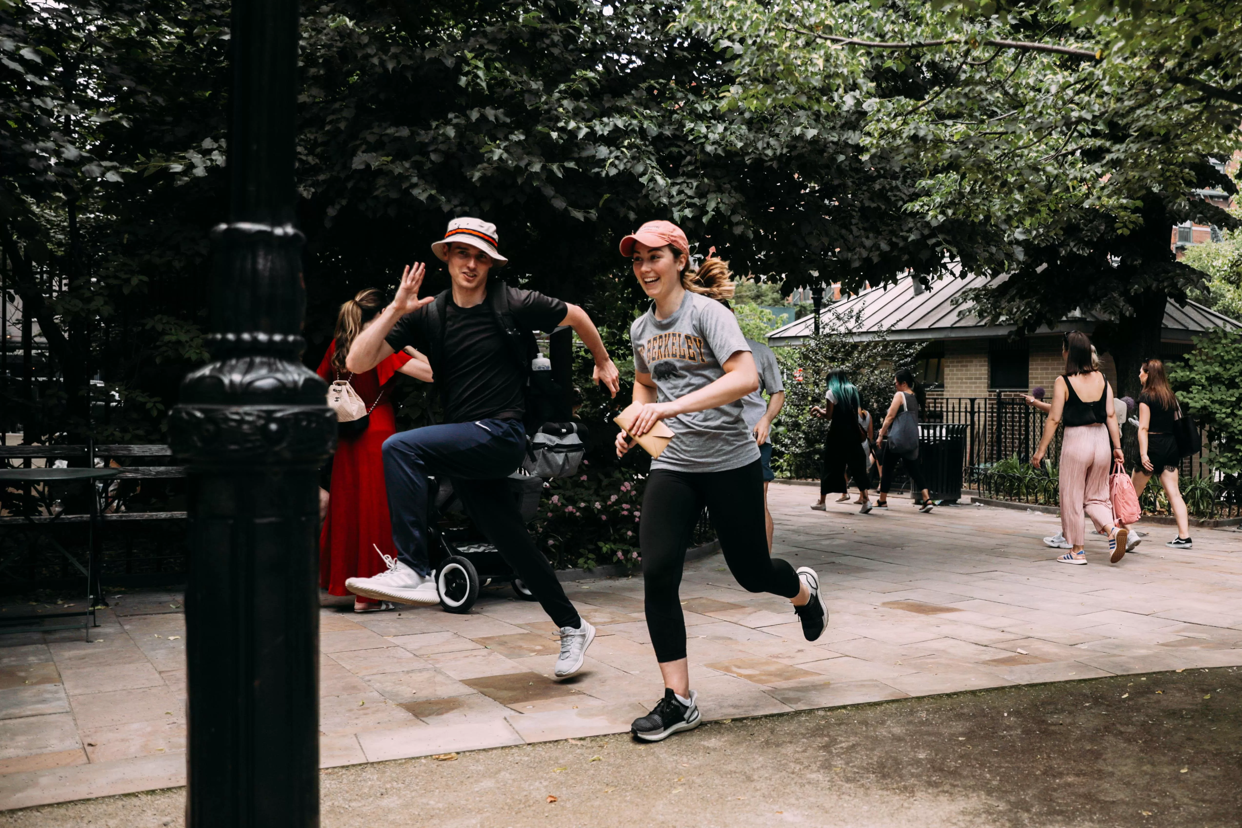 Two people running through central park on a scavenger hunt.