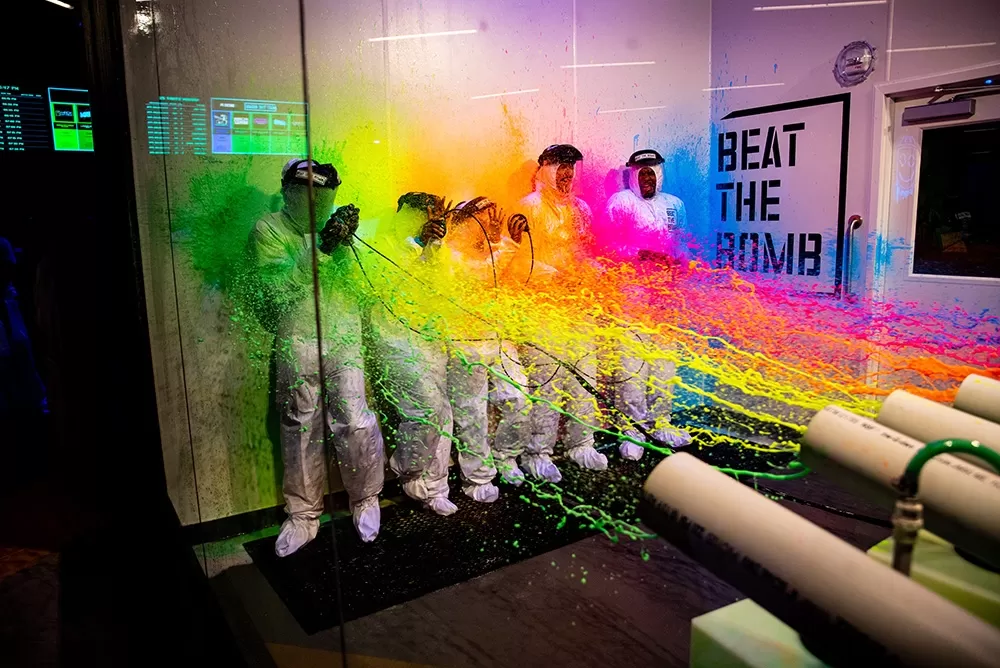 A group of people being sprayed with paint at beat the bomb.